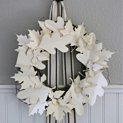 Fall Wreath made with cream colored paper leaves hanging on a wall.