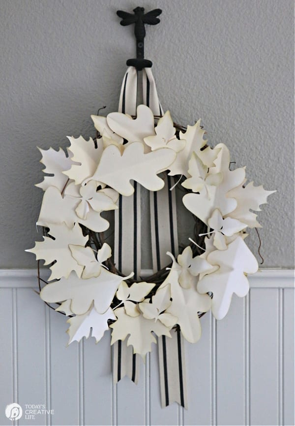 Fall Wreath made with cream colored paper leaves hanging on a wall.
