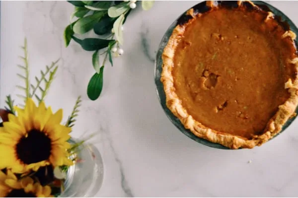 Baked whole Pumpkin Pie setting on counter.