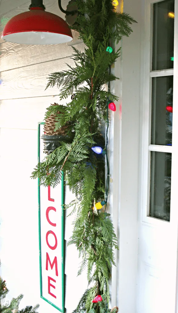 Green garland framing a door with holiday lights. 