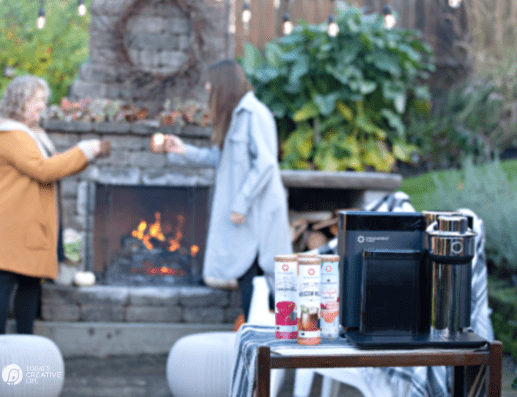 Drinkworks Home Bar with Two women standing next to outdoor fireplace 