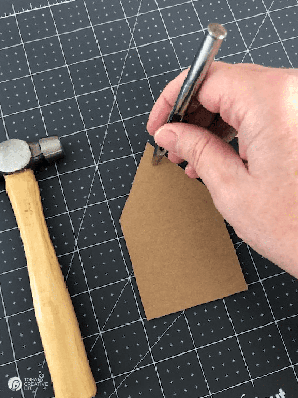 Punching a Hole in a chipboard shaped like a house.