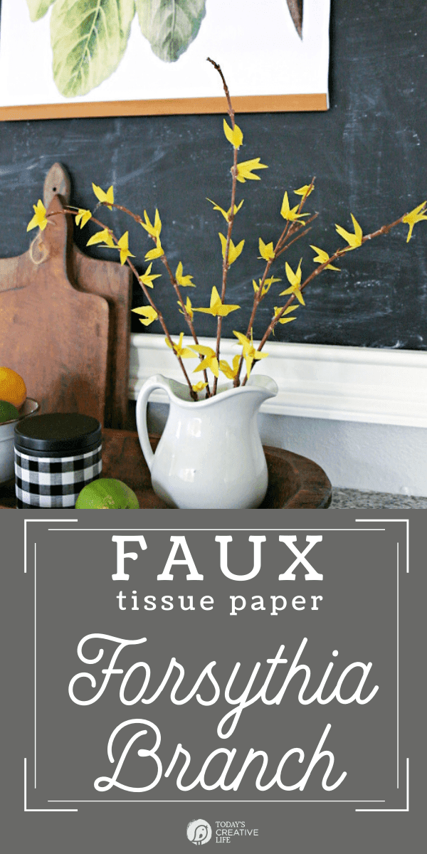 Faux Forsythia Branches made with yellow tissue paper, displayed in a white ceramic pitcher.