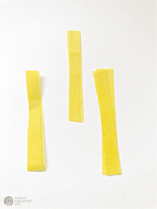 3 two inch pieces of yellow tissue paper for making diy tissue paper flowers.