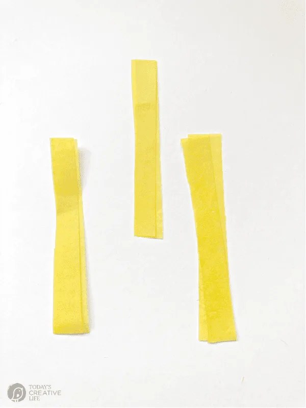 3 two inch pieces of yellow tissue paper for making diy tissue paper flowers.