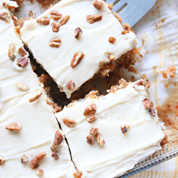 Carrot cake sliced up in squares in a cake pan.