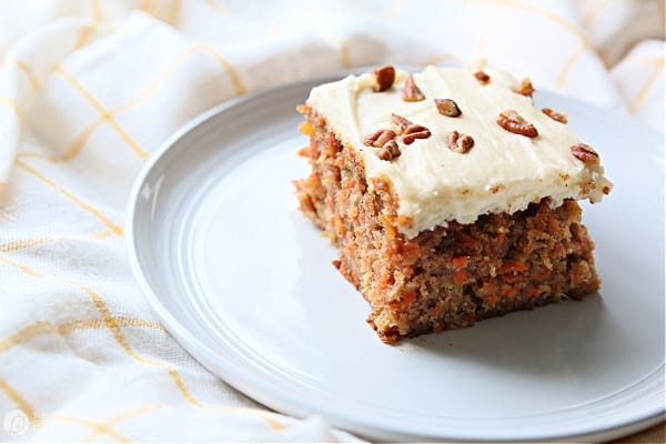 Carrot cake with frosting served on a white plate