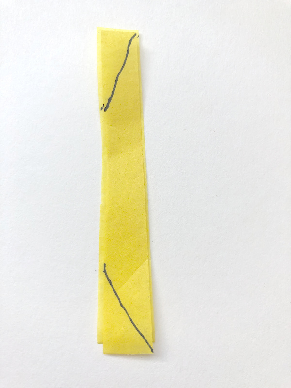 yellow tissue paper 2 -inch strip with markers on where to cut for making diy tissue paper flowers.