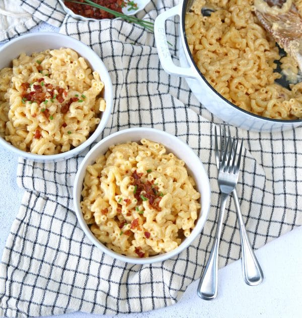 Overhead photo of a pot of stovetop mac and cheese with two filled bowls.