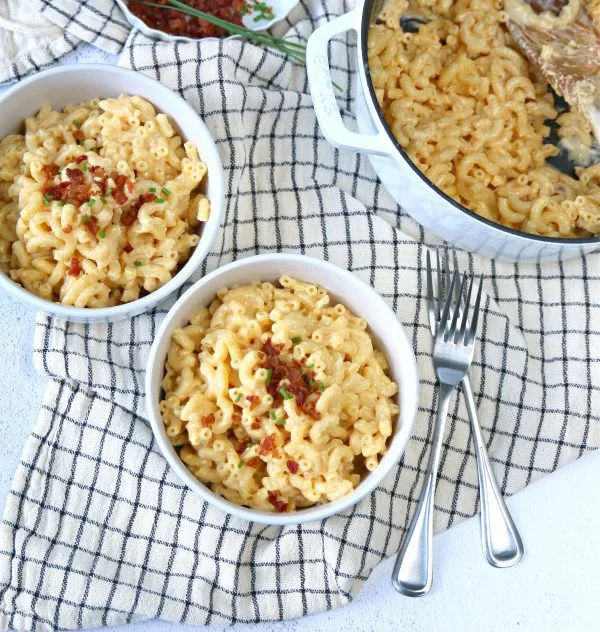 Overhead photo of a pot of stovetop mac and cheese with two filled bowls.