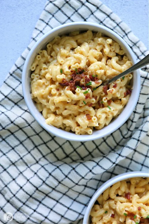 Mac and Cheese with bacon and chives in white bowls.