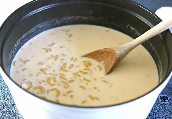 Large pot with water and evaporated milk for making homemade mac and cheese