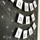 Printable Happy New Year Banner in black and white hung on a chalk board