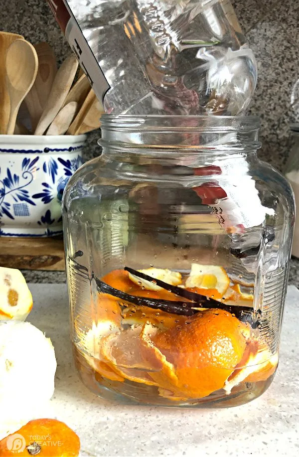 glass jar with orange peels and vanilla beans inside for making infused vodka