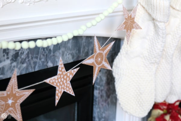 brown paper gingerbread stars hanging on mantel. Gingerbread decor for Christmas
