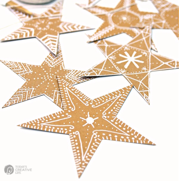 brown paper stars with white chalk marker for a gingerbread design. Easy Christmas DIY Decor