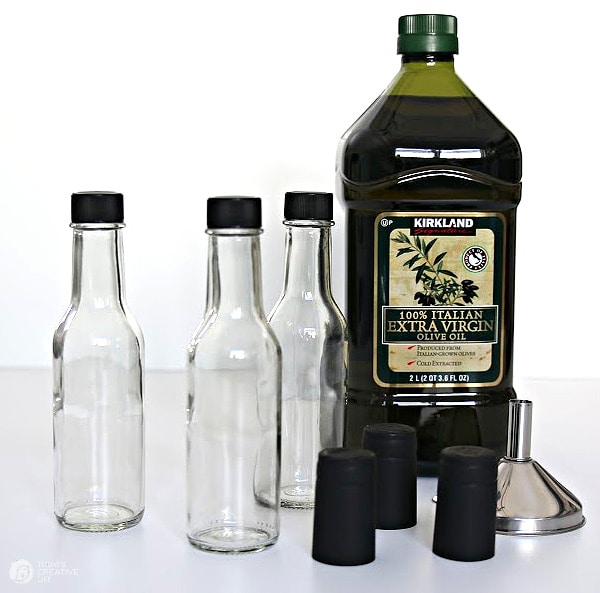 How to Infuse Olive Oil - large bottle of olive oil with clear bottles for filling.