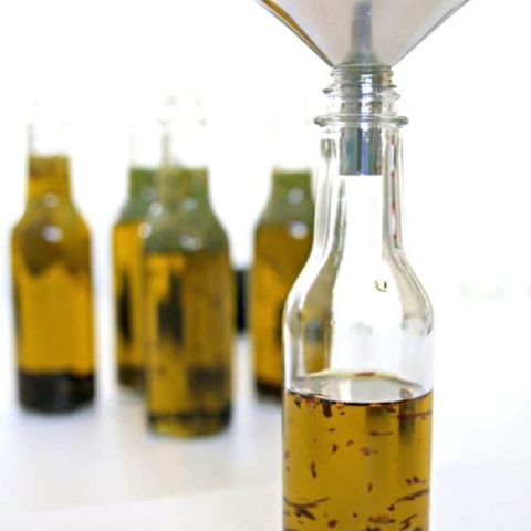 bottles filled with olive oil and herbs