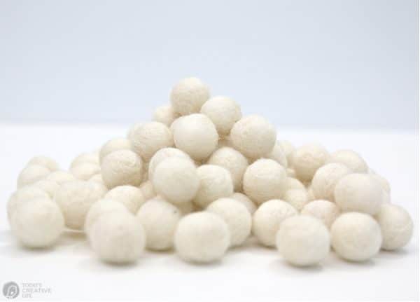 a pile of cream colored felted wool balls