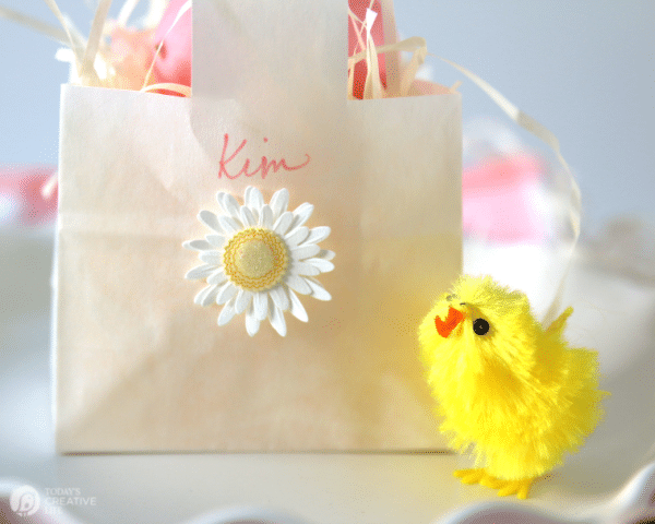 Small white paper bag made into a mini Easter basket for an Easter Table placesetting.