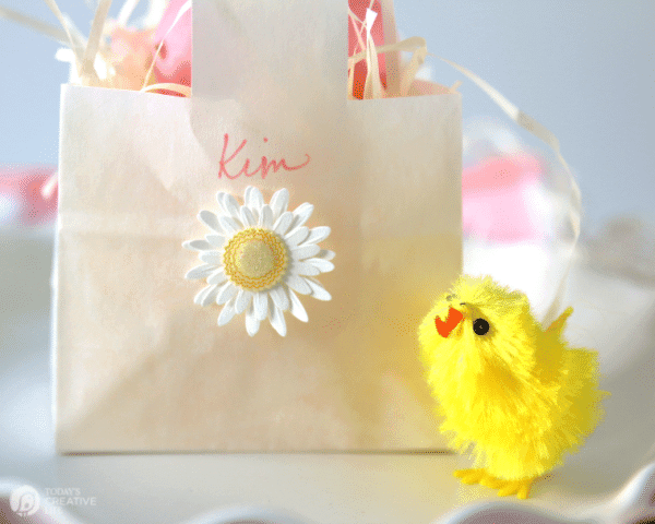 Small white paper bag made into a mini Easter basket for an Easter Table placesetting.