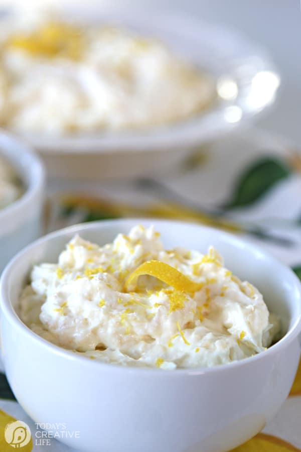 2 white bowls filled with Pineapple Lemon Fluff Recipe with a lemon twist garnish