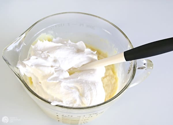 Pineapple Lemon Fluff Recipe ingredients being mixed in a glass bowl.