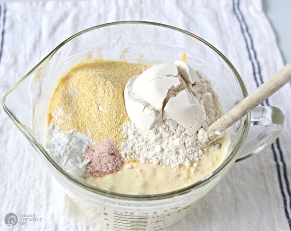 Mixing bowl with batter and mixing in dry ingredients for corn jalapeno bread