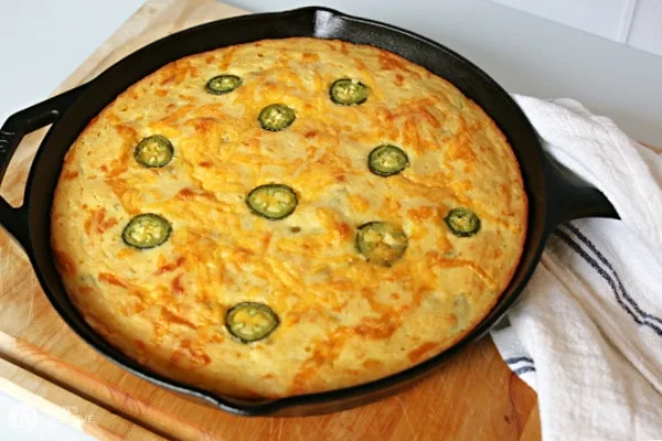 Baked golden brown corn jalapeno bread in a cast iron skillet.