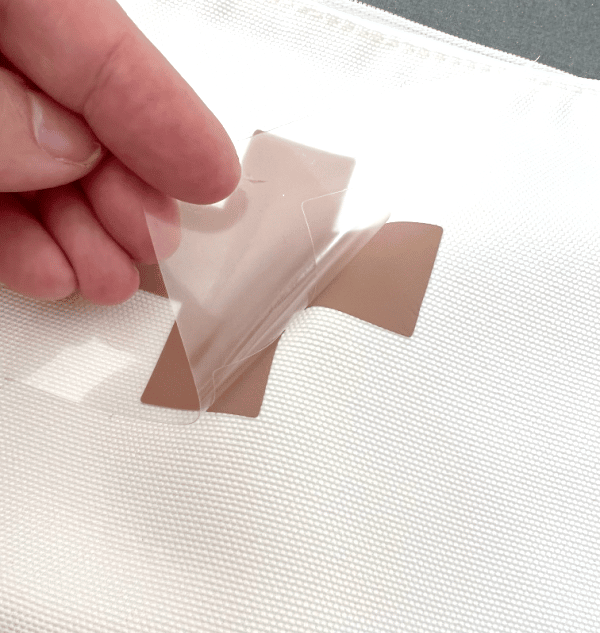 Peeling top sheet from iron-on design.