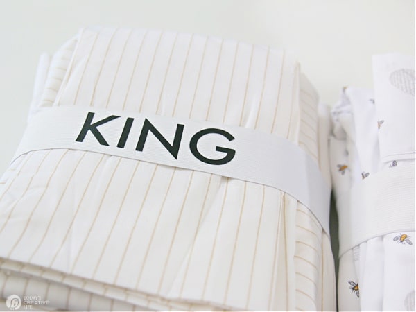 Set of sheets with elastic wrapped around that says KING
