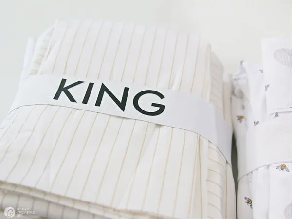 Set of sheets with elastic wrapped around that says KING