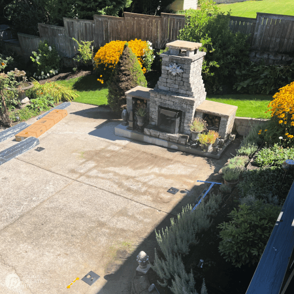 Backyard with concrete pad and a stone fireplace