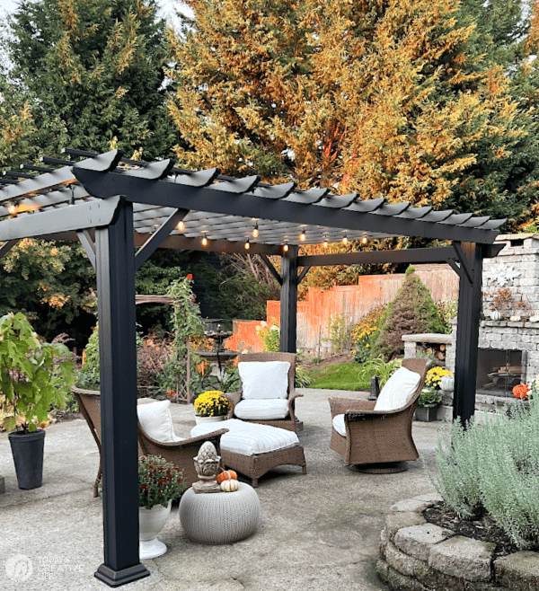 Black Pergola kits | Backyard view with patio furniture under a metal black pergola