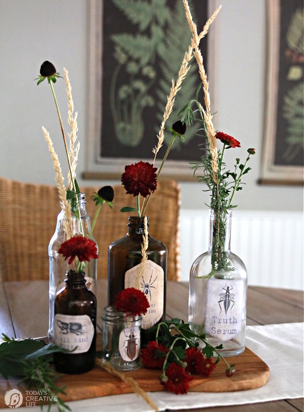Halloween Apothecary Jars decorated with flowers on a table