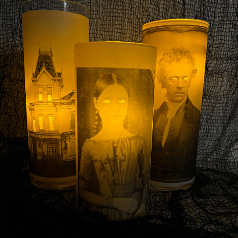 Three glowing glass vases with victorian photos.