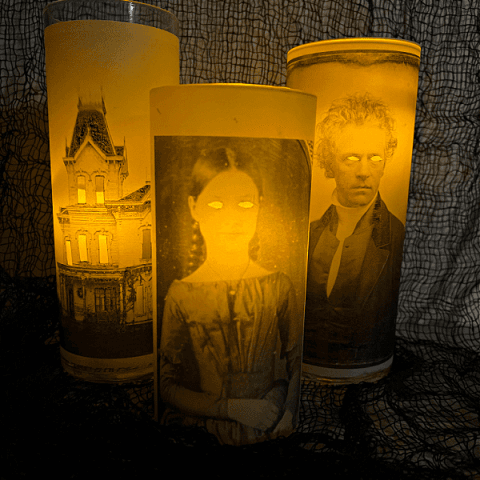 Three glowing glass vases with victorian photos.