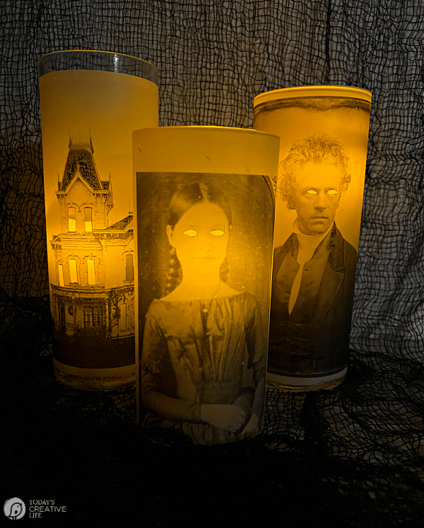 Three glowing glass vases with victorian photos.