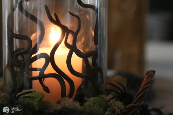 Glass vase with snakes and a candle