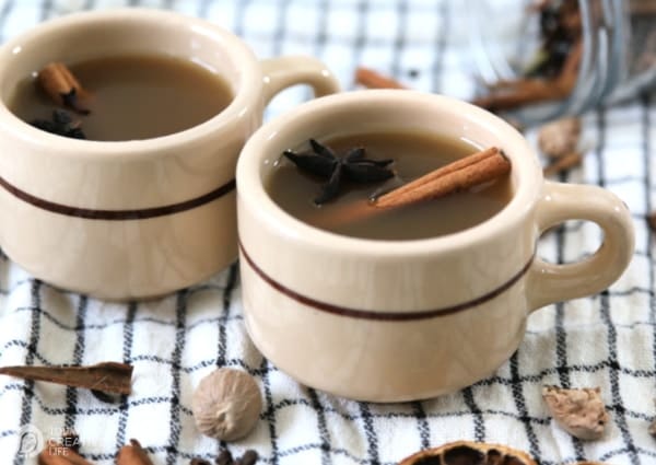 two mugs filled with hot spiced cider