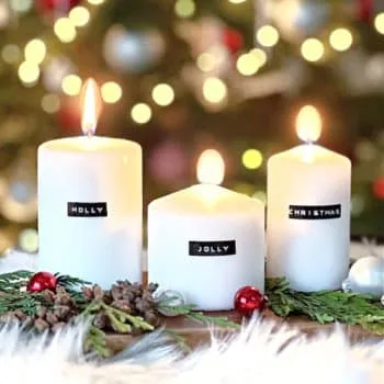 e white candles with Christmas lights behind.