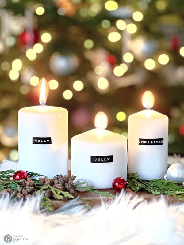 3 white pillar candles lit for DIY Christmas decorating ideas.