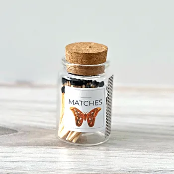 Bottle with butterfly label filled with wood matchsticks