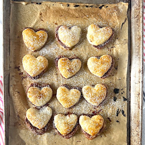 Puff pastry hearts baked golden brown on baking sheet