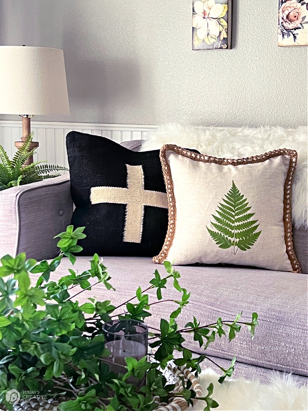 Two pillows on a grey sofa. Decorated in neutrals.