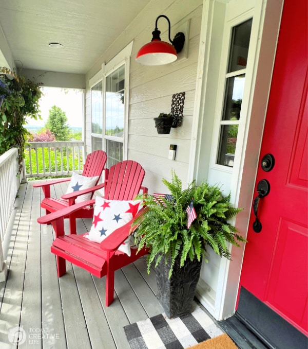 Patriotic Decorating Ideas on a front porch that has a red door, with red chairs. 