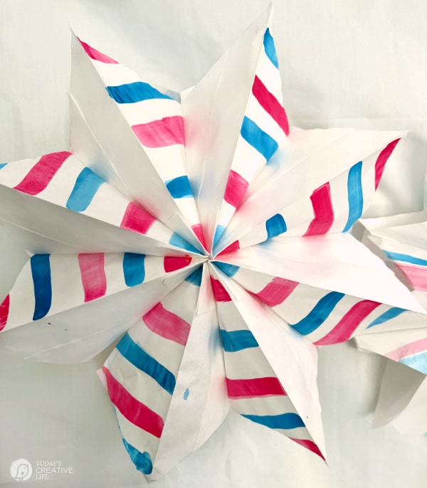 White paper star with red and blue painted stripes.
