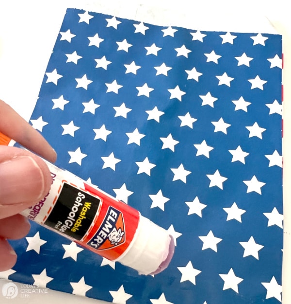 Adding glue to a blue bag with stars