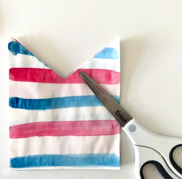 Painted paper bag with a V cut in the top.