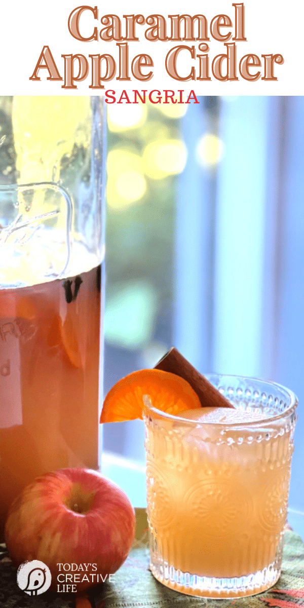 Apple Cider Sangria with Caramel recipe. Glass filled and garnished with an orange.